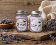 Two lavender-scented candles labeled 'A Calming Ritual' on a wooden surface with lavender flowers.