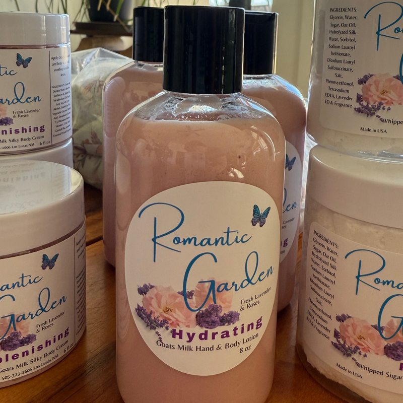 Bottle of Romantic Garden Hydrating Goats Milk Hand & Body Lotion with pink liquid visible through the transparent packaging, featuring floral design and product information on the label.