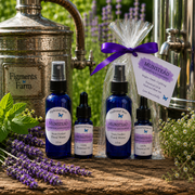 Four bottles of Munstead Lavender & Peony Herbal Oil and Water arranged on a rustic wooden surface with lavender sprigs, green herbs, and metal apothecary equipment in the background. One bottle is wrapped in cellophane with a purple ribbon and a product tag.