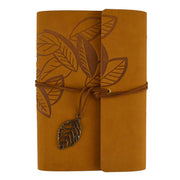 A rolled tan leather journal with an embossed leaf pattern, wrapped with a brown leather cord and a small metal leaf charm, shown on a plain white background.