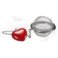 A stainless steel tea infuser with a red heart-shaped fob attached by a chain.