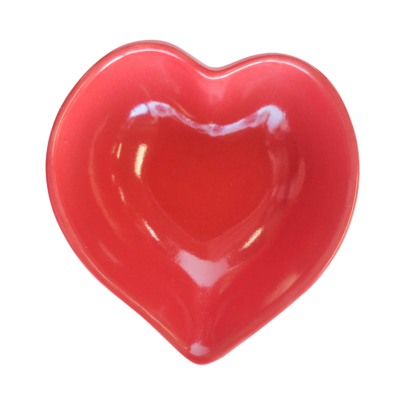 A red ceramic dish in the shape of a heart.